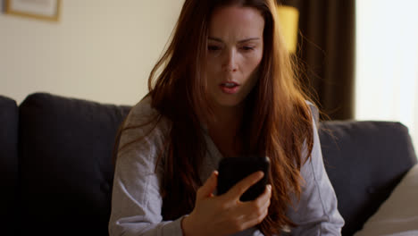 Anxious-Woman-Lying-On-Sofa-At-Home-Looking-At-Mobile-Phone-Concerned-About-Social-Media-Or-Bad-News-1